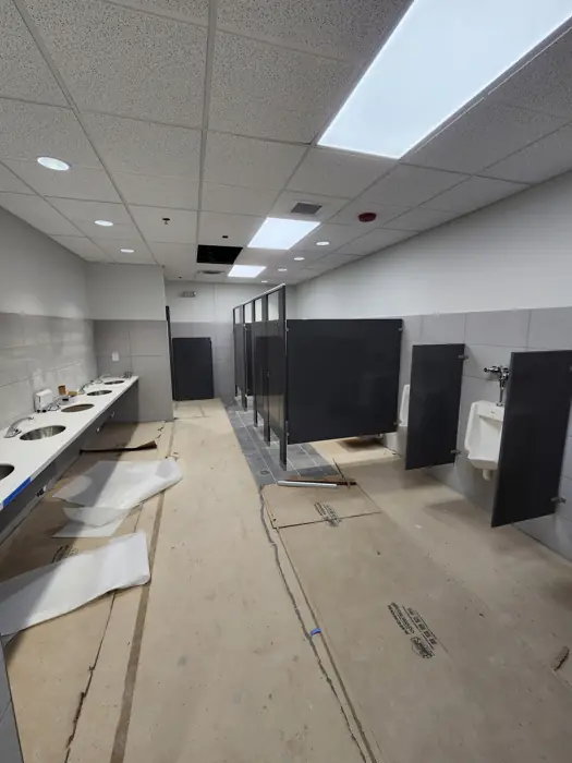 Commercial restroom with toilet partitions and acoustical ceiling