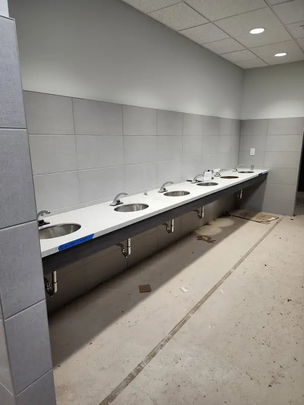 Commercial restroom with long multi-sink vanity counter
